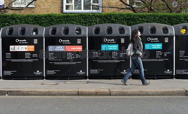 young-woman-walking-by-a-row-of-recycle-bins-london-england-uk-c2fh3h